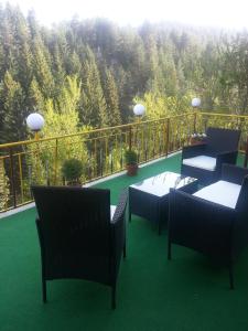 a balcony with tables and chairs and a view of a mountain at Guest House Stoletnika in Yagodina