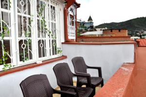3 sillas sentadas en el balcón de un edificio en Old Tbilisi Rhymes en Tiflis