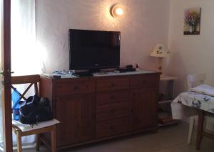una TV in cima a un comò in legno in una stanza di Teresa Holiday Home a Porto Cervo