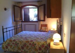 ポルト・チェルボにあるTeresa Holiday Homeのベッドルーム1室(花柄のベッドカバー、窓付)