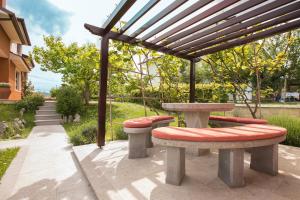 una mesa de picnic y bancos bajo una pérgola en Apartment Kampel, en Koper