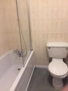 a bathroom with a toilet and a tub with a shower at The Avenue Hotel in Grantham