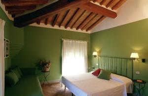 um quarto verde com uma cama e um sofá em Villa Ducci em San Gimignano