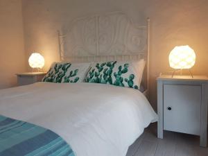 a bedroom with a large white bed with two lamps at Ca' Viscomi in San Teodoro