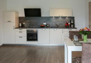 a kitchen with white cabinets and a counter top at Ferienwohnung zur Schönen Aussicht-Rüters Parkhotel in Willingen