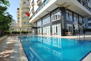 a swimming pool in front of a building at Hotel Royal Hill in Antalya