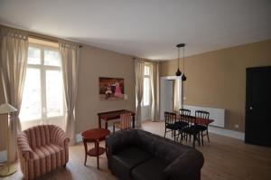 ein Wohnzimmer mit einem Sofa, einem Tisch und Stühlen in der Unterkunft L'Empereur, sa Femme et le petit Prince in Plombières-les-Bains
