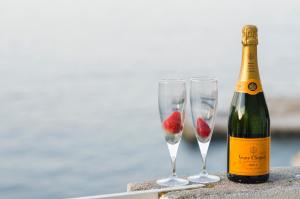 una bottiglia di champagne e due bicchieri di champagne con una fragola di Apartments Dora Mljet a Kozarica