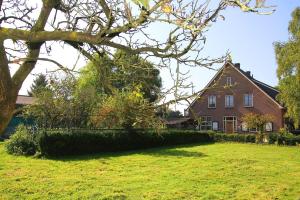 una casa con un árbol delante de un patio en Bed and Breakfast Maas en Waal en Winssen