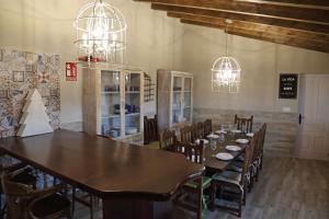 ein Esszimmer mit Tisch und Stühlen und Kronleuchtern in der Unterkunft La Casa del Corro in Villanueva de San Mancio