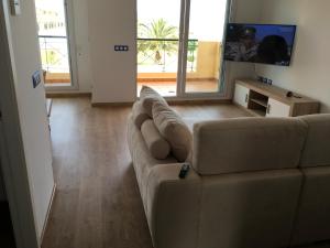 a living room with a couch and a television at Oliva Nova Casas del Mar in Oliva