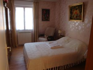 1 dormitorio con 1 cama, 1 silla y 1 ventana en La Tuilerie, en Noyers-sur-Cher