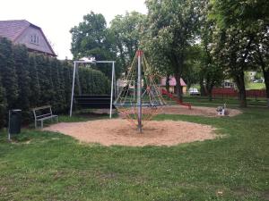 a playground in a park with a dog sitting next to it at Apartment Šárka in Strupčice