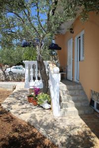 a tree on the side of a house with stairs at Apartmani Šprljan in Vodice