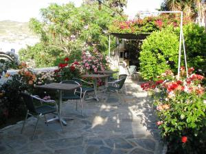 a patio with tables and chairs and flowers at Anna Studios in Katapola