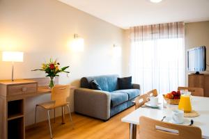 a living room with a couch and a table at Lagrange Aparthotel Toulouse Saint-Michel in Toulouse