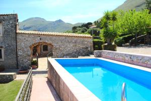 uma piscina em frente a uma casa com montanhas ao fundo em Casale Maddalena em Carini