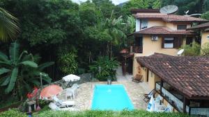a house with a swimming pool next to a house at Vila São Pedro in Ilhabela +29 photos