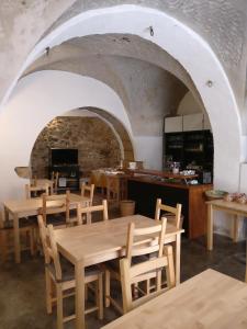 restauracja z drewnianymi stołami i krzesłami oraz kuchnią w obiekcie B&B Porta della Terra w mieście Militello in Val di Catania