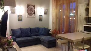 Appartamento con giardino privato في سانتو ستيفانو أل ماري: غرفة معيشة مع أريكة زرقاء وطاولة