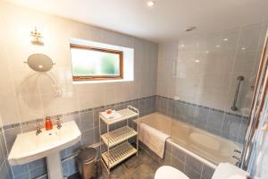 a bathroom with a tub and a sink and a toilet at Whitley Coach House in Whitley