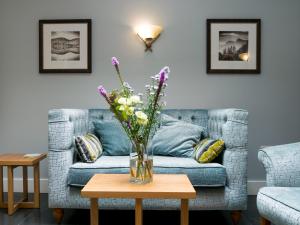 a vase of flowers on a table in a living room at Glaramara Hotel in Borrowdale Valley