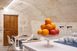 a bowl of oranges and apples on a table at Petit Hotel 5 Fars in Ciutadella
