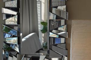 a wall of mirrors in a room with a window at All-in-One in Berlin