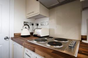 a kitchen with a stove top and a toaster oven at The Grapevine Studio in Cambridge +3 photos