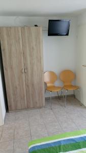a room with two chairs and a tv on a wall at Familie Fritz in Gager