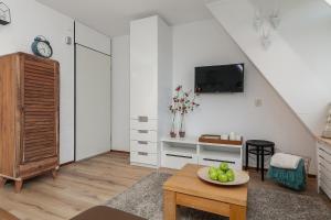 ein Wohnzimmer mit einem Tisch und einem TV an der Wand in der Unterkunft Perfect Stay Holiday, Sea View in Egmond aan Zee