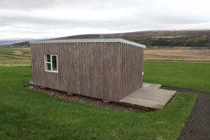a small wooden cabin in a field of grass at Fornhagi 2 in Akureyri