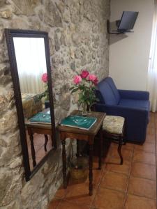 a living room with a blue couch and a mirror at La Posada del Rey in Llanes