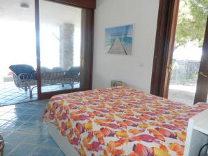a bedroom with a bed with a colorful comforter at Villa Giglio Rosso in Campese