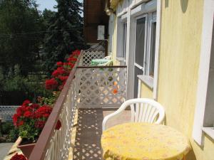 ハイドゥソボスローにあるOlga Apartmanházのバルコニー(花の飾られたテーブルと椅子付)