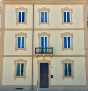 un edificio con ventanas azules y una puerta en Angioy 18 en Sassari