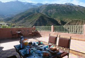 Tamatert Guest House في إمليل: طاولة وكراسي على فناء مطل على الجبال