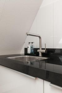 a sink with a faucet in a bathroom at Perfect Stay Holiday, Sea View in Egmond aan Zee