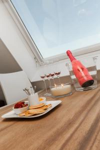 einen Tisch mit einem Teller Essen und einer Flasche Wein in der Unterkunft Perfect Stay Holiday, Sea View in Egmond aan Zee