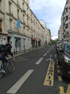 a person riding a bike down a city street at Hôtel Richard in Paris