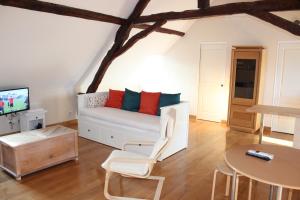 ein Wohnzimmer mit einem weißen Sofa und einem Tisch in der Unterkunft Le Studio in Montignac
