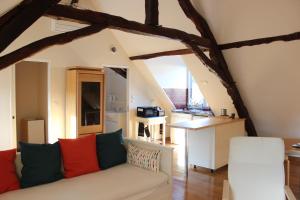 a living room with a couch and a kitchen at Le Studio in Montignac