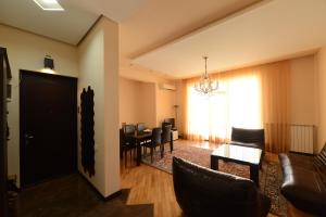 a living room with a couch and a table and chairs at Meri's Apartment in Batumi