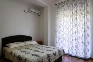 a bedroom with a bed and a large window at Apart Hotel Forte Roses Montenegro KO Buljarica in Petrovac na Moru