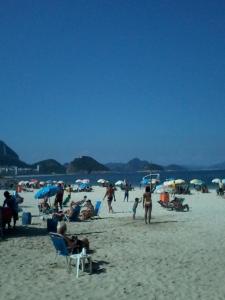 a group of people on a beach with umbrellas at Copacabana POSTO 4 Temporada in Copacabana