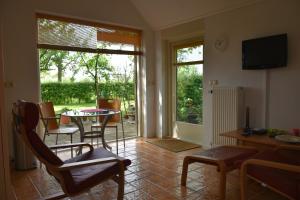 een woonkamer met een tafel en stoelen en een raam bij Beeldend Buiten in Wichmond