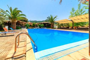 a swimming pool in a resort with palm trees at Kissos Apartments in Vourvourou