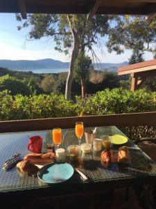 einen Tisch mit Gläsern Orangensaft und Essen darauf in der Unterkunft Hotel Les Hauts de Porto-Vecchio in Porto-Vecchio