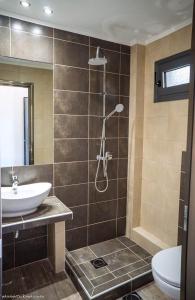 a bathroom with a shower and a sink and a toilet at Life's Moments in Limenaria