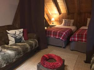 a room with two beds and a chair and a couch at La Clé des Bois in Le Bourg-dʼOisans